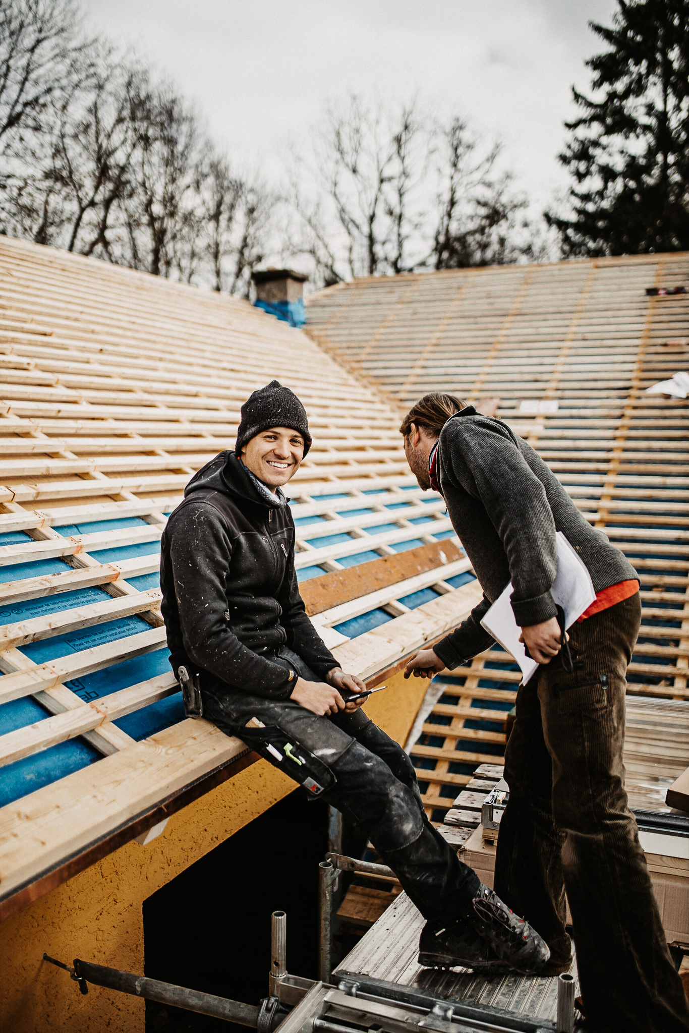 Zwei Handwerker bei Dacharbeiten und Holzbau